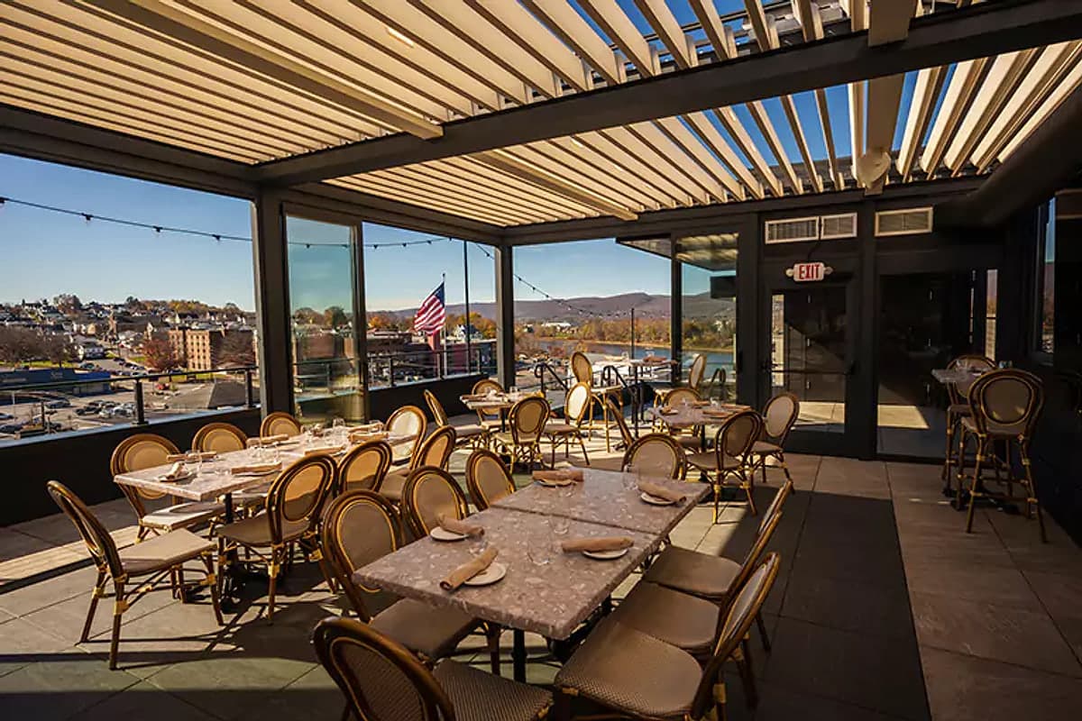 Rooftop restaurant under a louvred roof with glass side enclosures